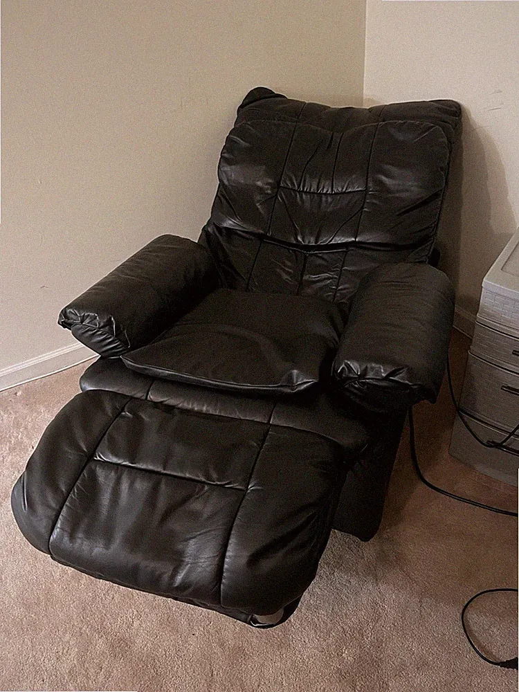 Black leather reclining massage chair with remote control attached for Options